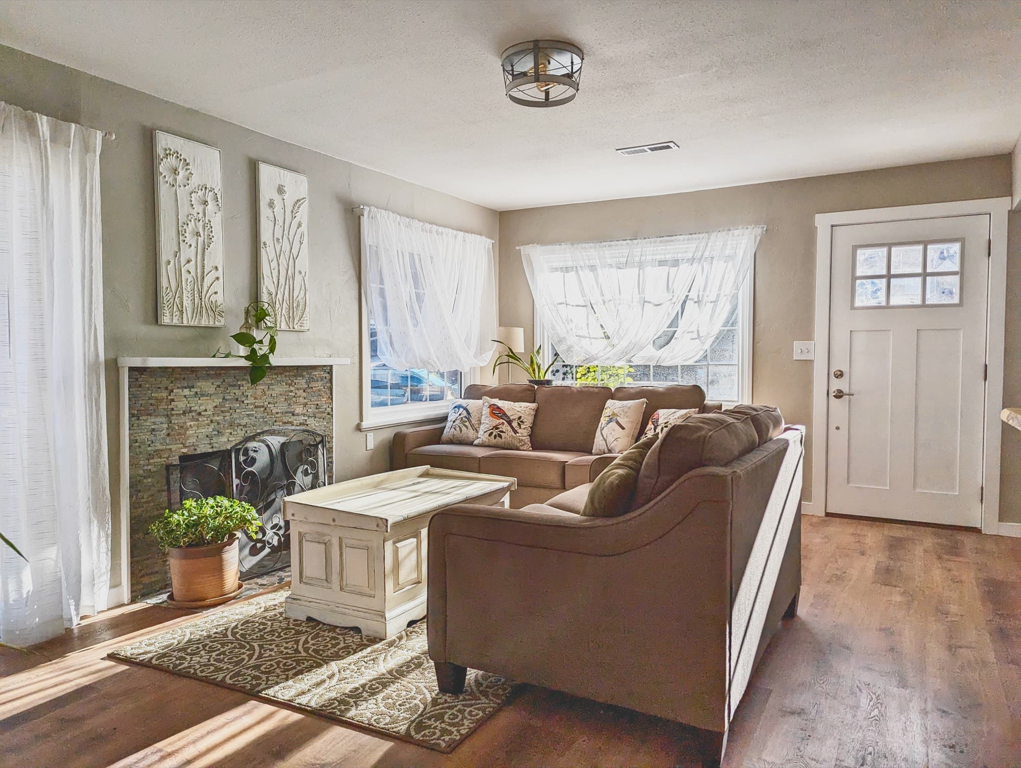 A living room with two sofas, a fireplace, and warm hardwood floors